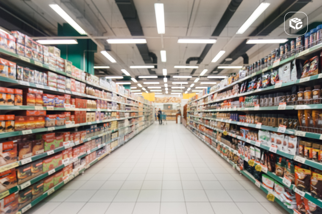 Corredor de supermercado com prateleiras cheias de produtos alimentícios.
